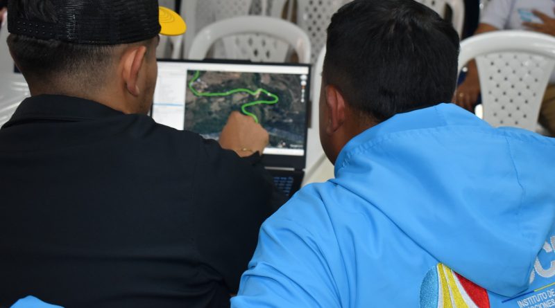 Equipo de trabajo de la Unidad Nacional de la Unidad de Riesgo, revisando imágenes de mapas en el computador