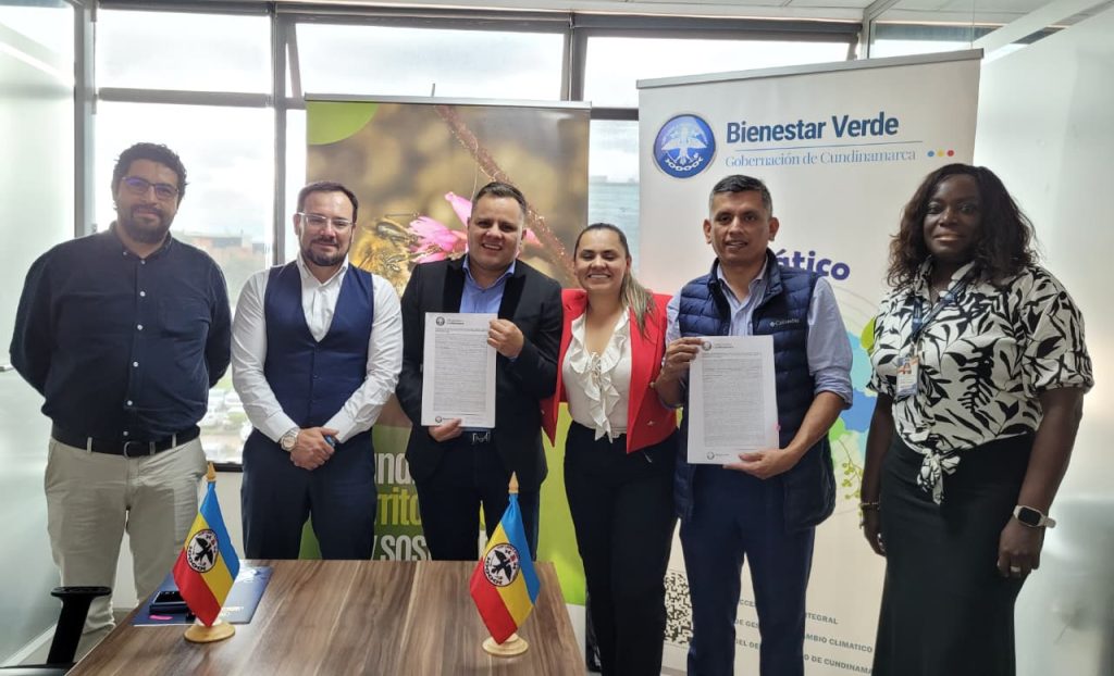 Grupo de funcionarios firmando una acta.