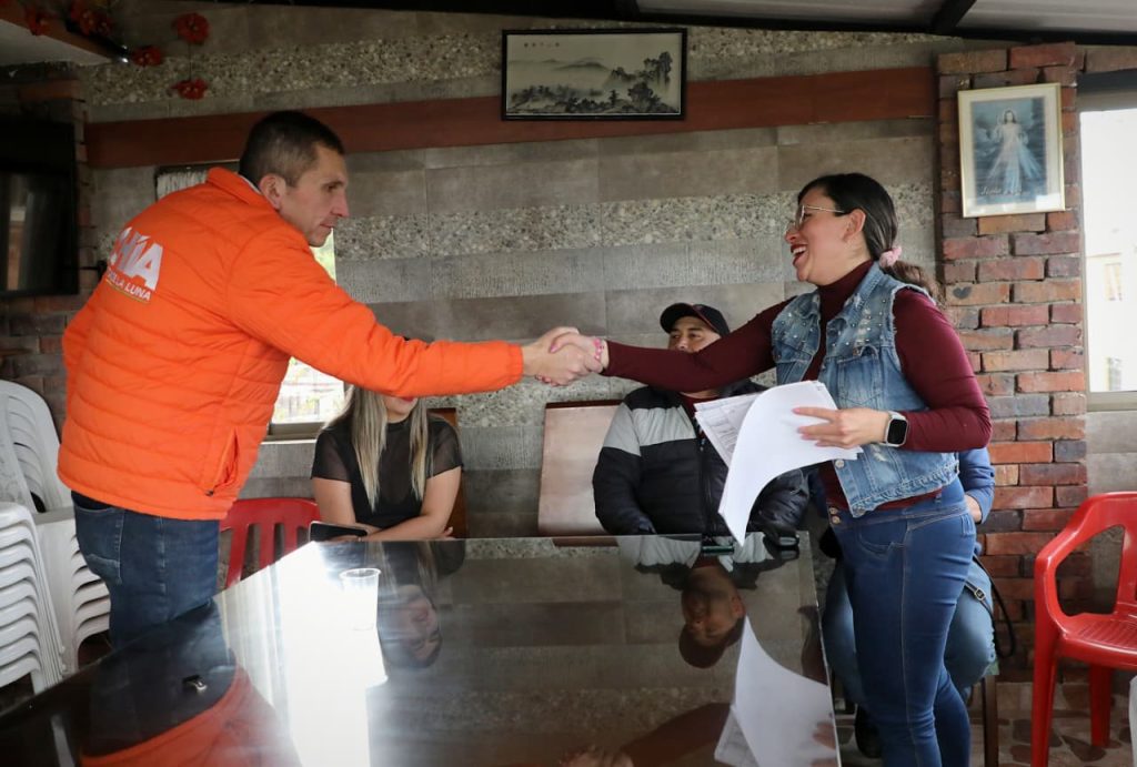 Alcalde dando la mano a una señora.