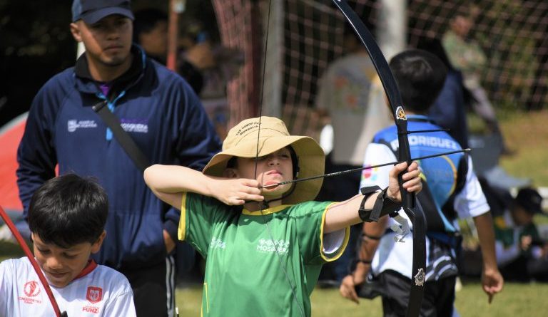 Niño con arco, apuntándole a la diana.