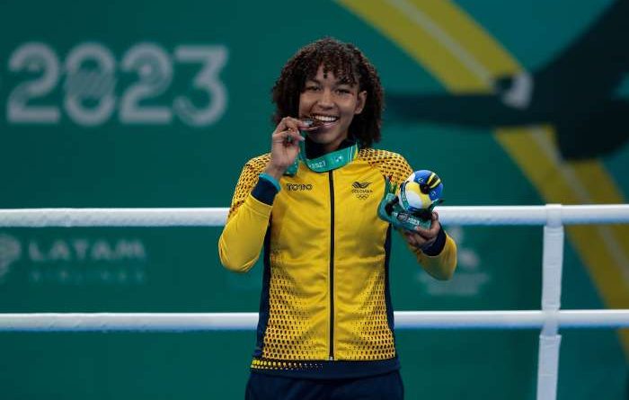 Medallista Colombiana mordiendo la medalla
