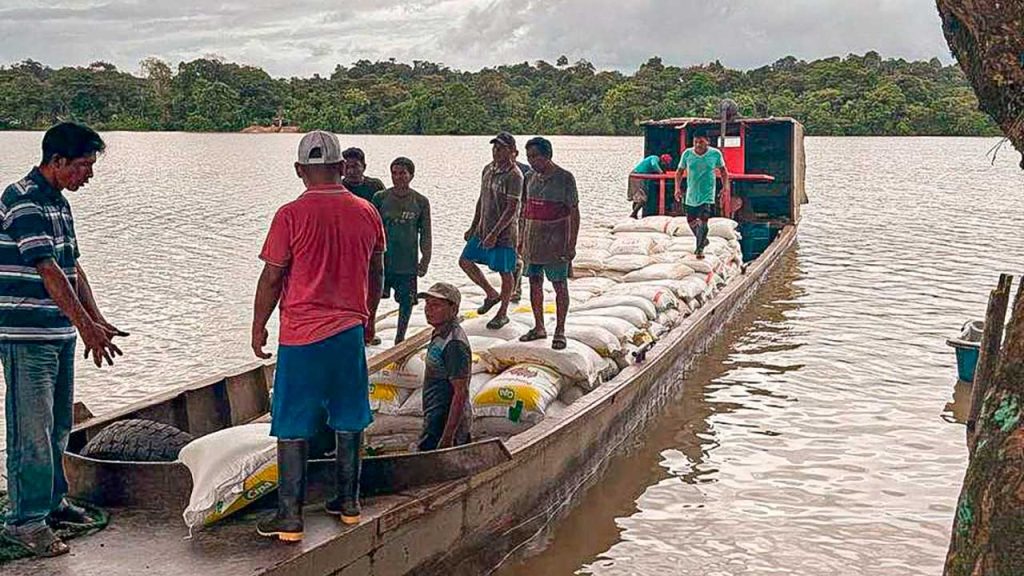 Pescadores indígenas en lancha sacando pescados del río