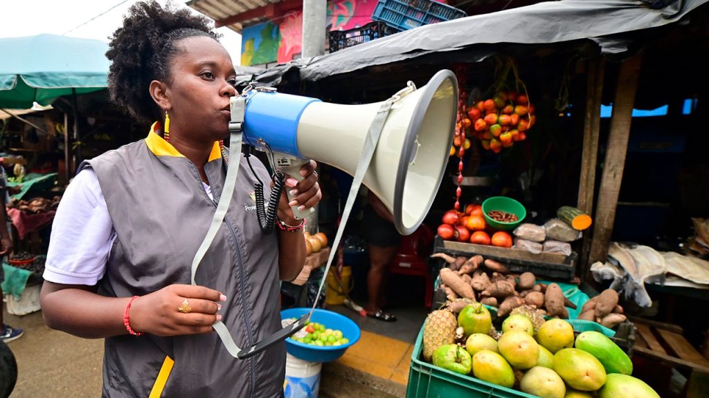 Mujer Afro con megáfono en plaza de mercado