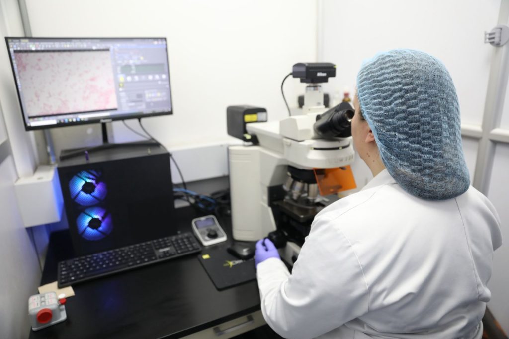 Bacterióloga en el laboratorio analizando muestras.