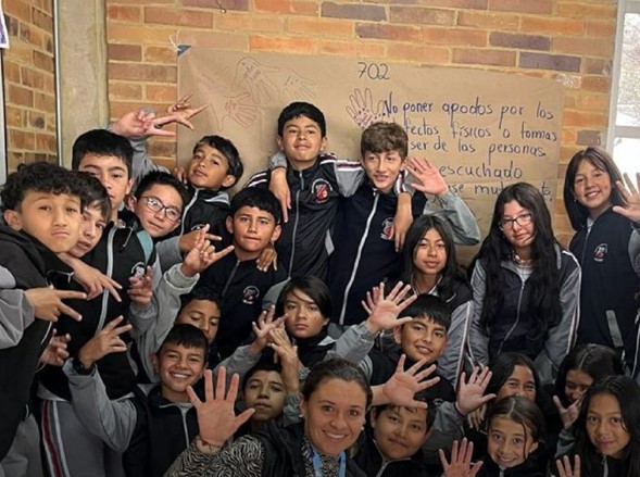 Estudiantes de colegio con las manos arriba