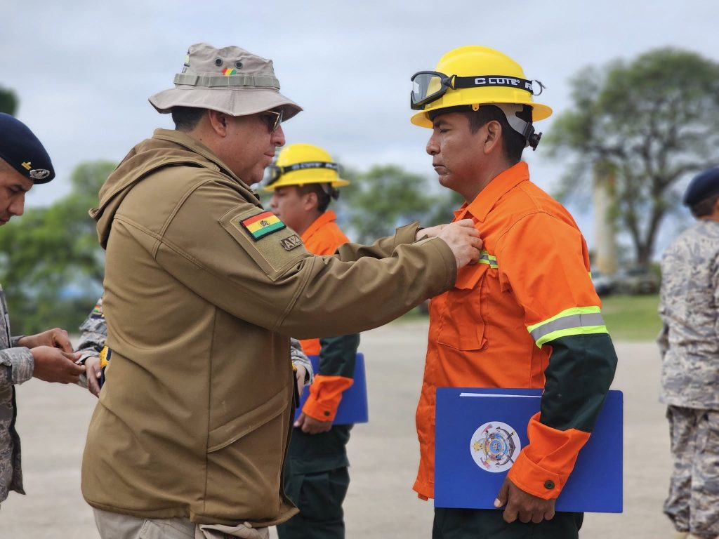 Un funcionario de la red de bomberos de Colombia galardonando a los Bomberos de Cundinamarca