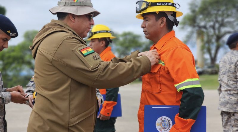 Un funcionario de la red de bomberos de Colombia galardonando a los Bomberos de Cundinamarca