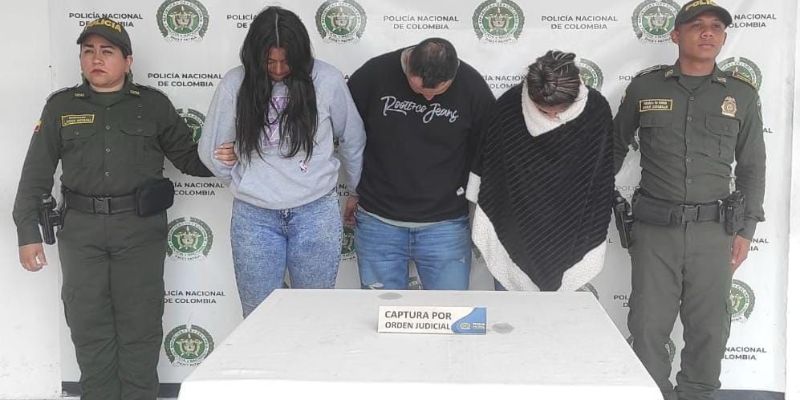 cinco personas en la foro, dos policías y dos hombres y una mujer como presuntos homicidas con la cabeza agachada.