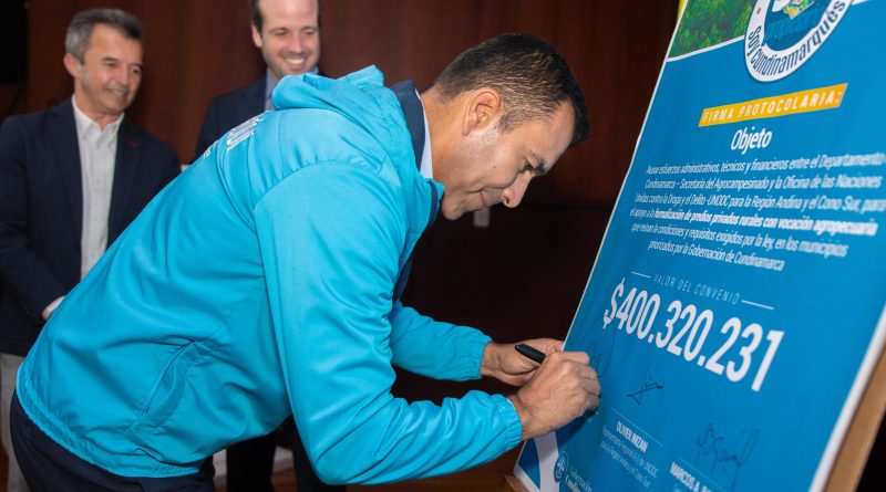 Gobernador de Cundinamarca firmando un tabloide donde muestra el convenio con el Agro.