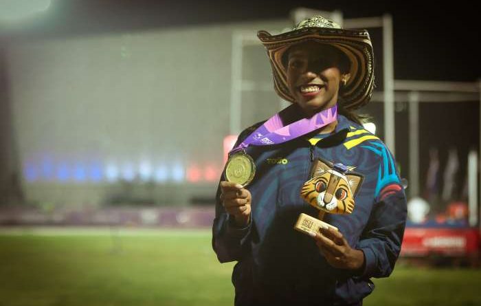 Deportista de patinaje con presea de oro en el cuello.