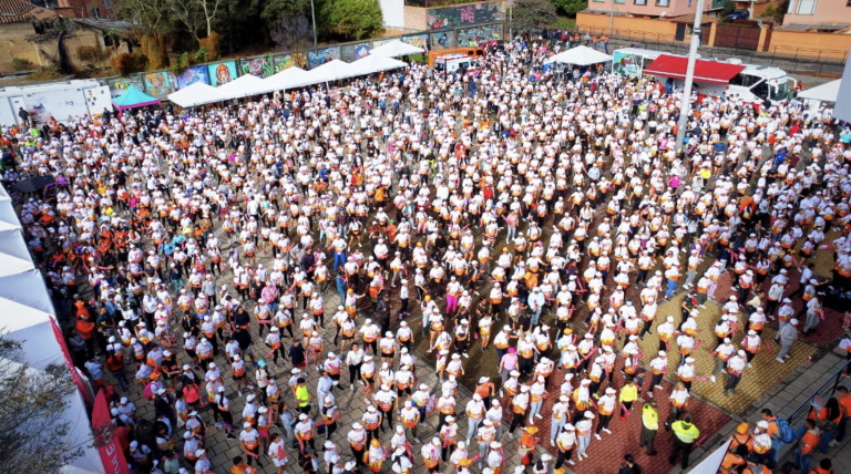 Grupo de cientos de mujeres haciendo ejercicio.