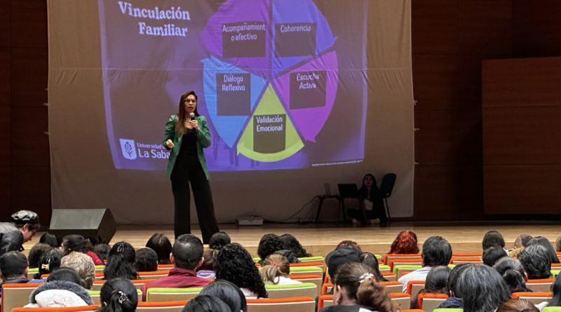 Mujer en tarima hablando de Paz escolar.