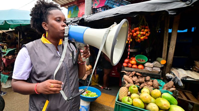 Mujer Afro con megáfono en plaza de mercado