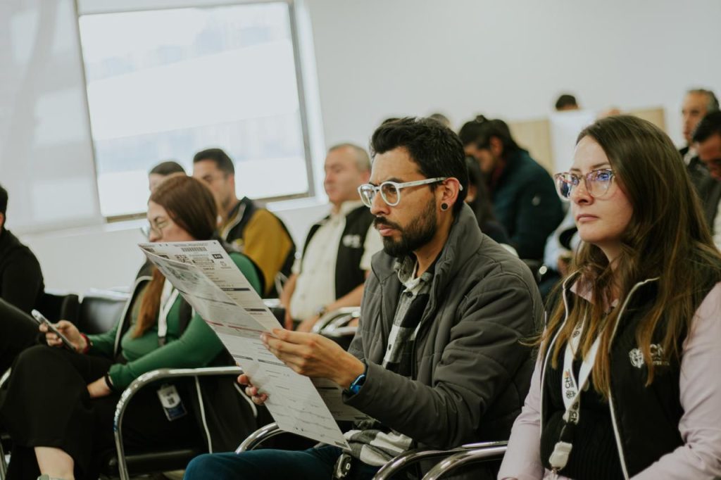 Grupo de personas tomando atención en la charla de la CNE