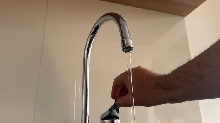 Llave de agua monitoreando la salida del agua para reciclar